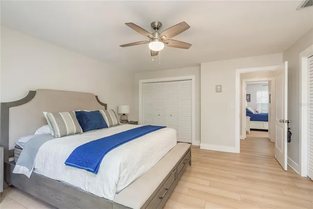 a bed room with a bed and a ceiling fan