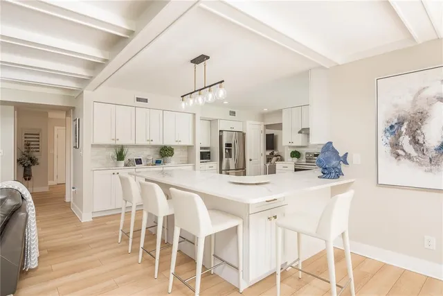 a kitchen with stainless steel appliances kitchen island granite countertop a table and chairs in it