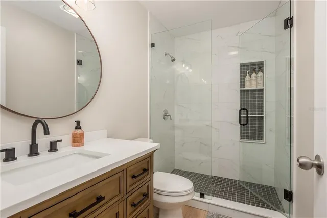 a bathroom with a sink a toilet and shower