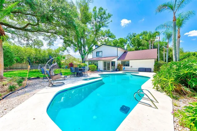 a view of a house with swimming pool and sitting area