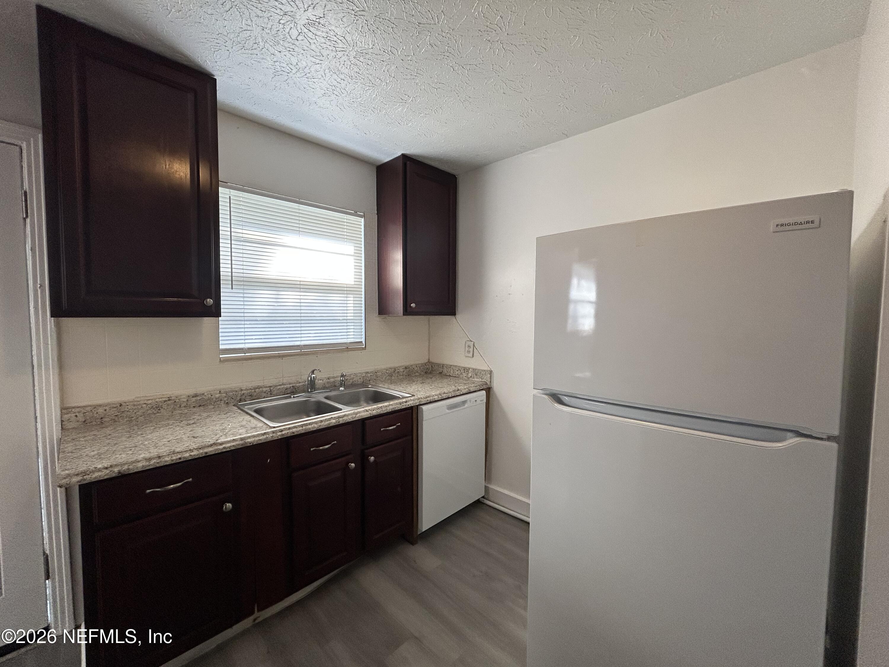 10610 Lone Star Road Jacksonville, FL 32225 - Photo 4 of 18 a kitchen with a sink and a refrigerator