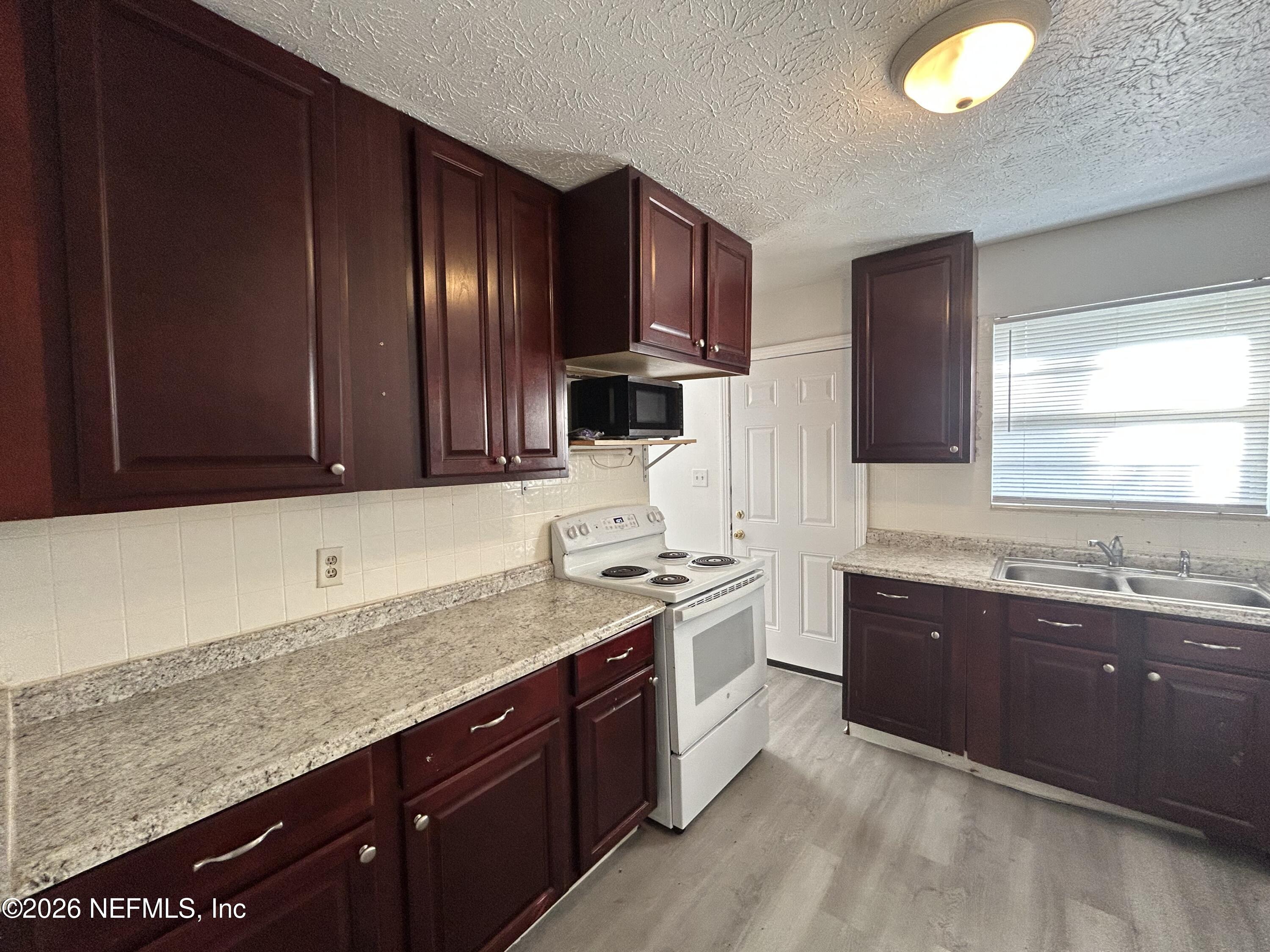 10610 Lone Star Road Jacksonville, FL 32225 - Photo 5 of 18 a kitchen with stainless steel appliances granite countertop wooden cabinets a sink and dishwasher