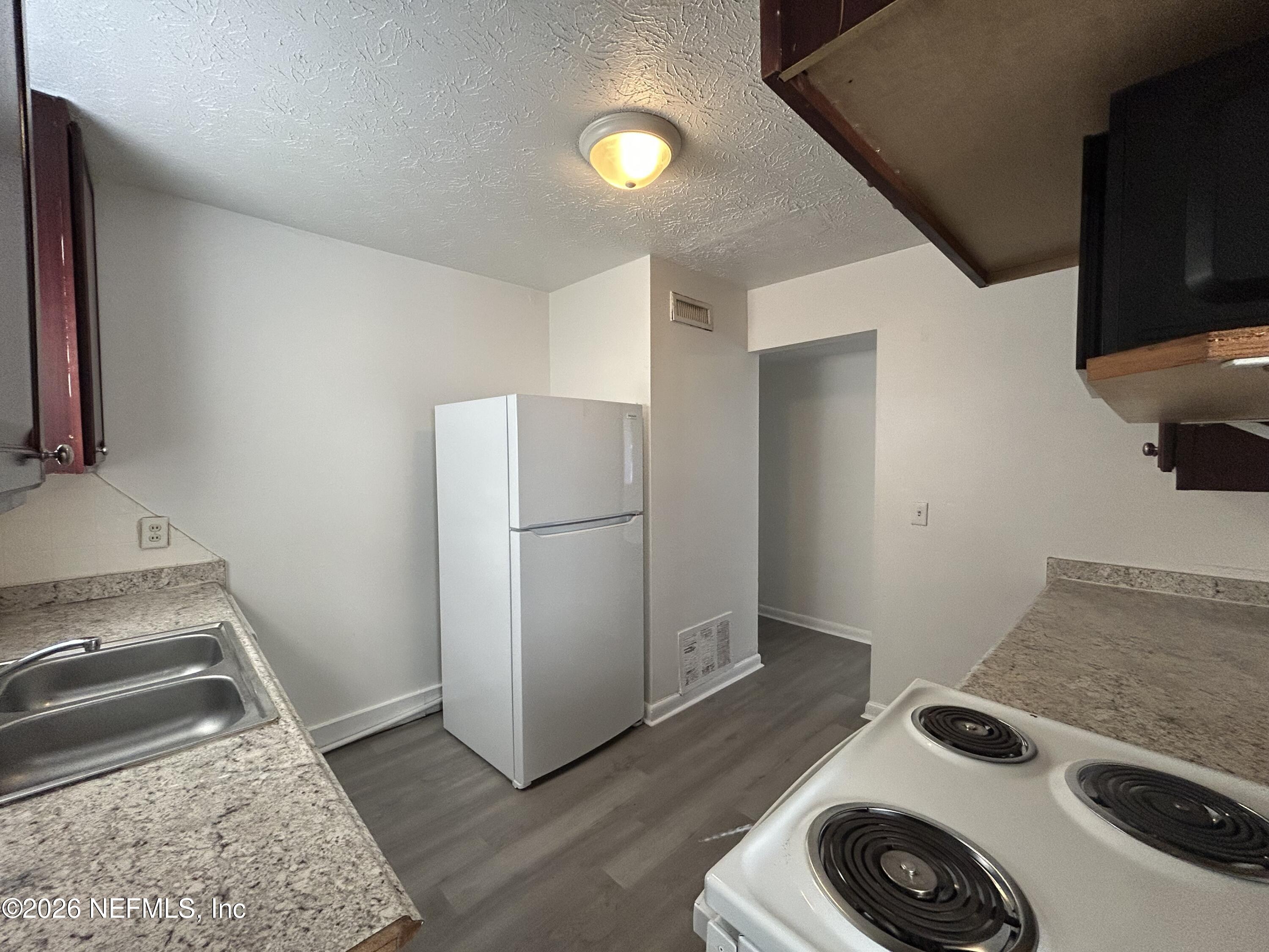 10610 Lone Star Road Jacksonville, FL 32225 - Photo 6 of 18 a kitchen with a stove and a refrigerator