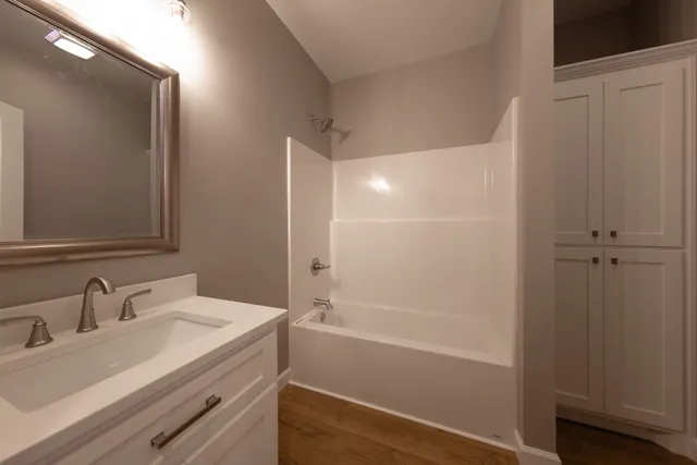 a bathroom with a granite countertop sink toilet and shower