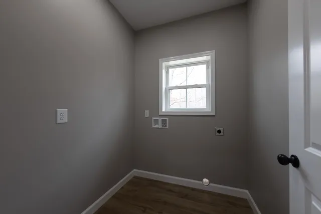 a view of a small space with wooden floor and a window