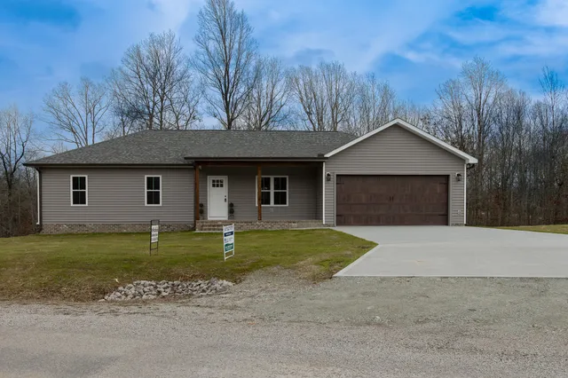 a front view of a house with a garden and yard