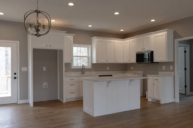 a large kitchen with stainless steel appliances granite countertop a stove and a sink