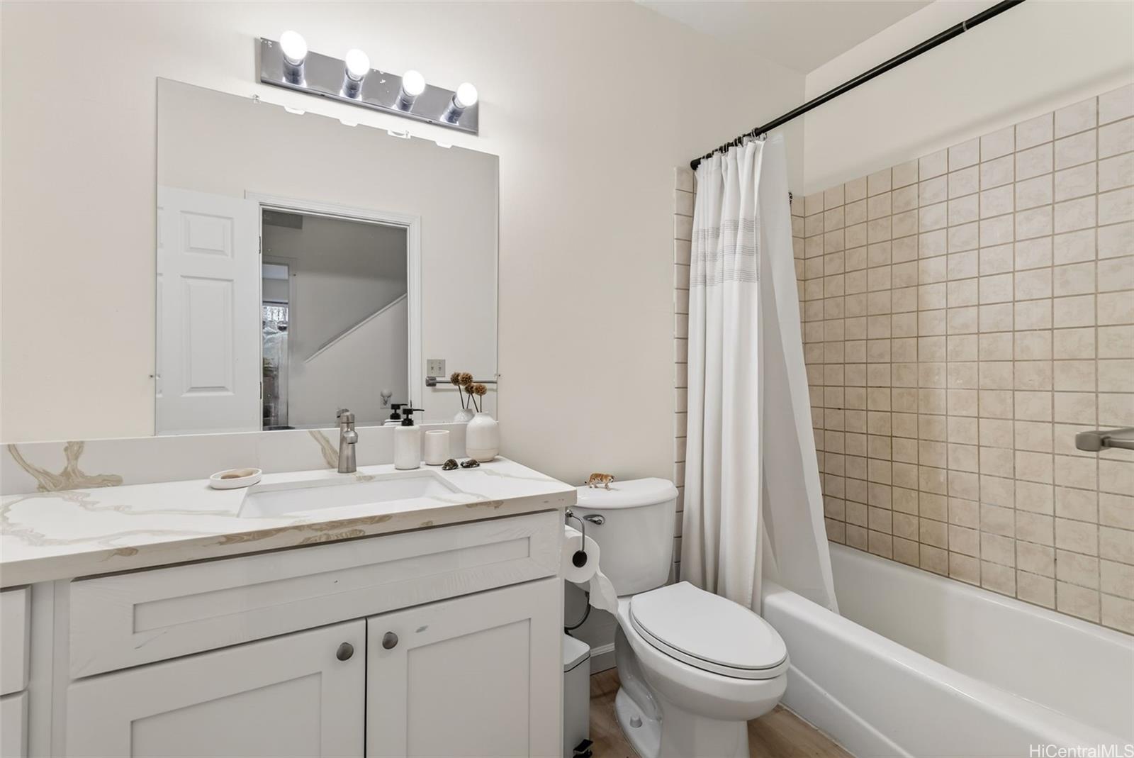 5207 Poola Street Honolulu, HI 96821 - Photo 14 of 25 a bathroom with a sink a toilet a mirror a vanity and shower