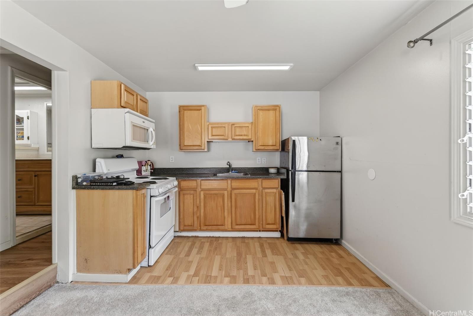 5207 Poola Street Honolulu, HI 96821 - Photo 19 of 25 a kitchen with granite countertop a refrigerator and a stove top oven