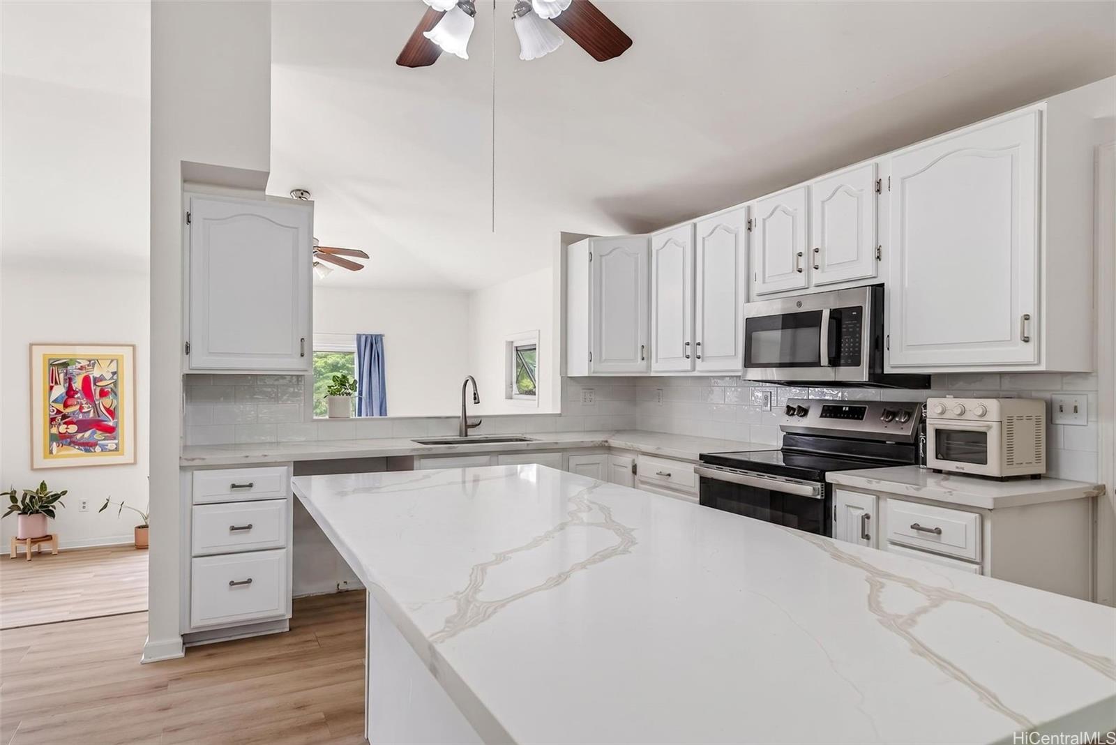 5207 Poola Street Honolulu, HI 96821 - Photo 5 of 25 a kitchen with granite countertop a sink a counter space appliances and cabinets