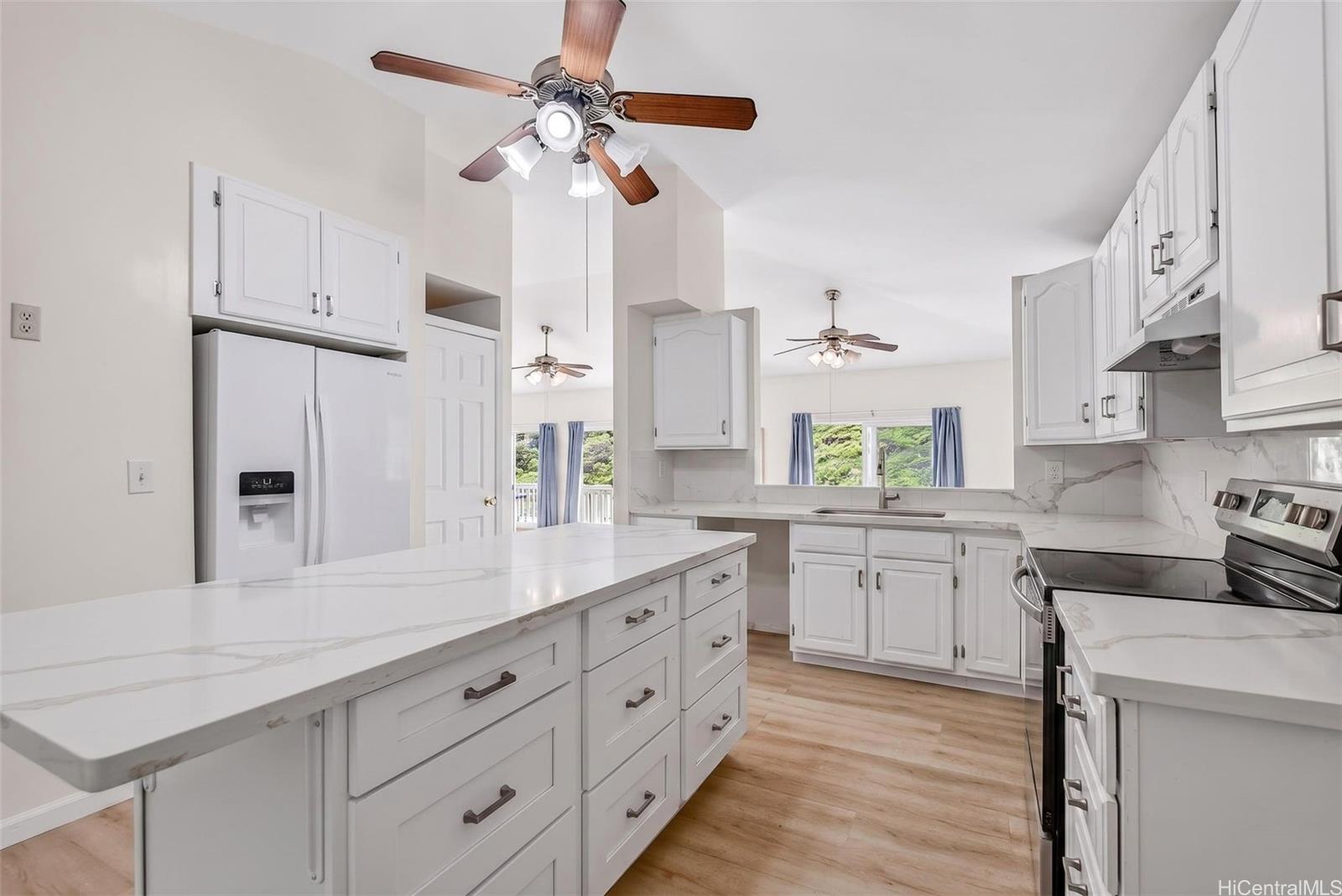 5207 Poola Street Honolulu, HI 96821 - Photo 6 of 25 a kitchen with a white cabinets and chandelier