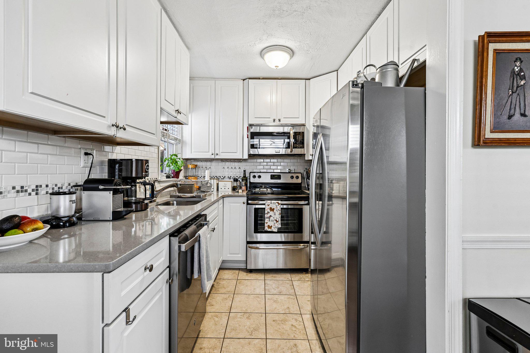 10419 Huntley Avenue Silver Spring, MD 20902 - Photo 11 of 42 a kitchen with stainless steel appliances granite countertop a refrigerator a stove and a sink