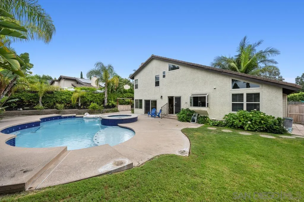 a view of a house with pool and a yard