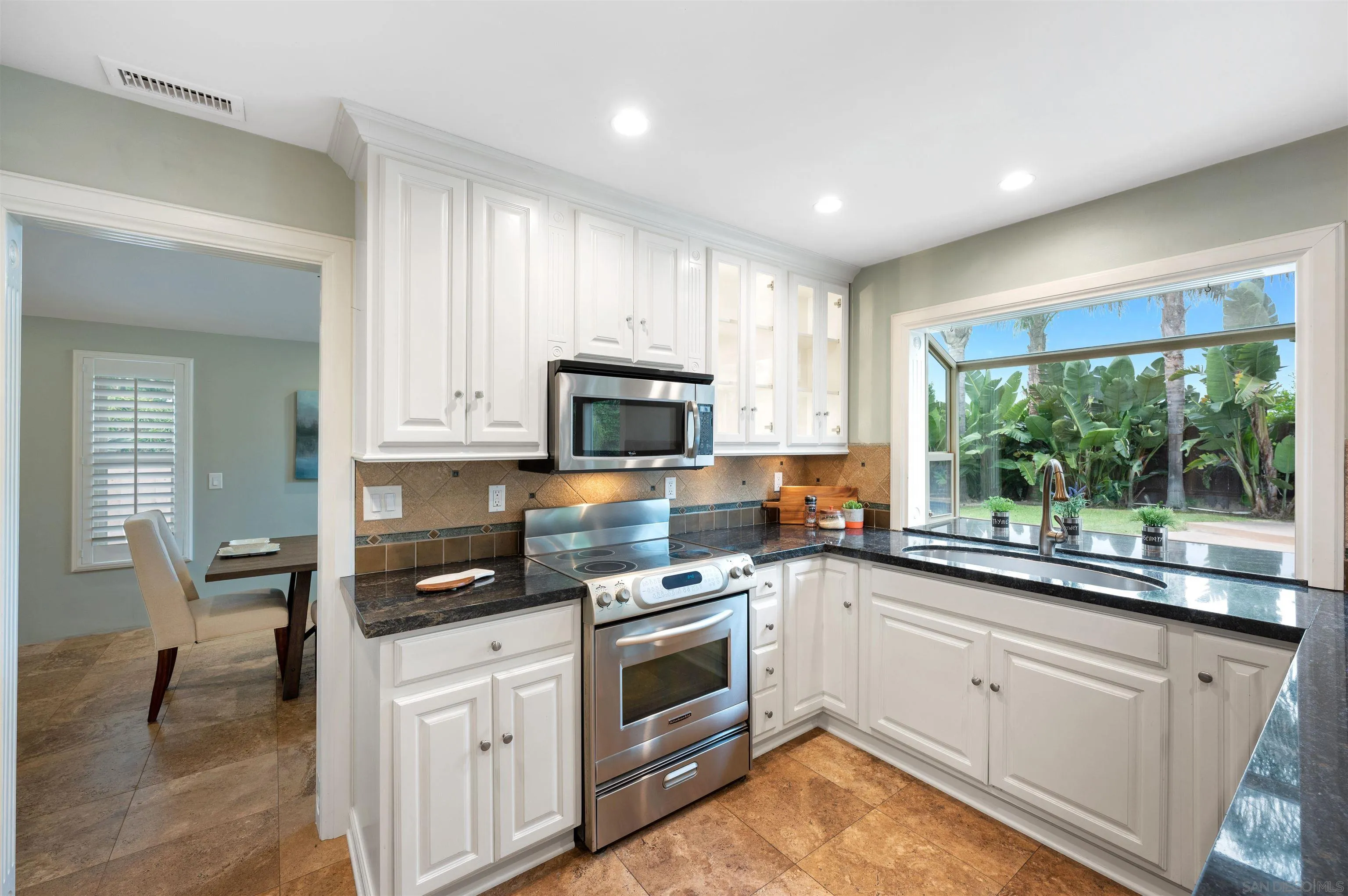 2312 Marca Place Carlsbad, CA 92009 - Photo 16 of 56 a kitchen with white cabinets and appliances