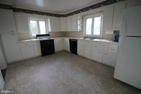 a kitchen with a white cabinets and window