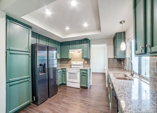 a kitchen with stainless steel appliances granite countertop a refrigerator and a stove