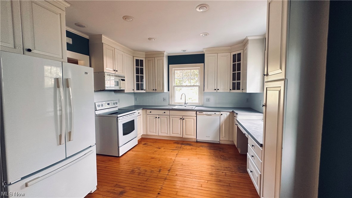 2927 Huntington Road Cleveland, OH 44120 - Photo 6 of 12 Kitchen with white appliances, ornamental molding, light hardwood floors, and white cabinets
