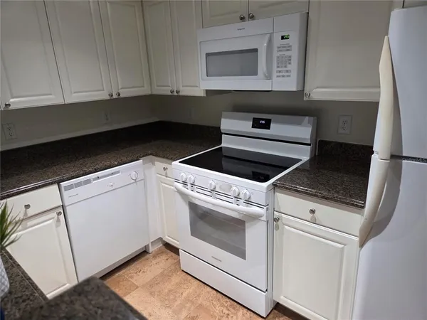 a kitchen with white cabinets and white appliances