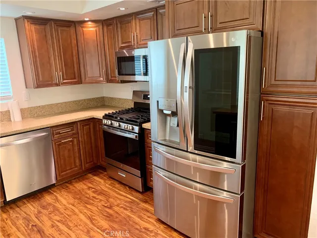 a kitchen with granite countertop stainless steel appliances and wooden cabinets
