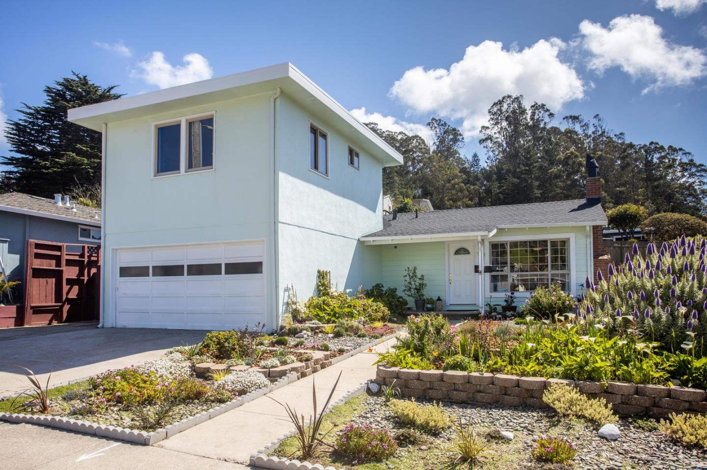 a front view of a house with a yard and potted plants