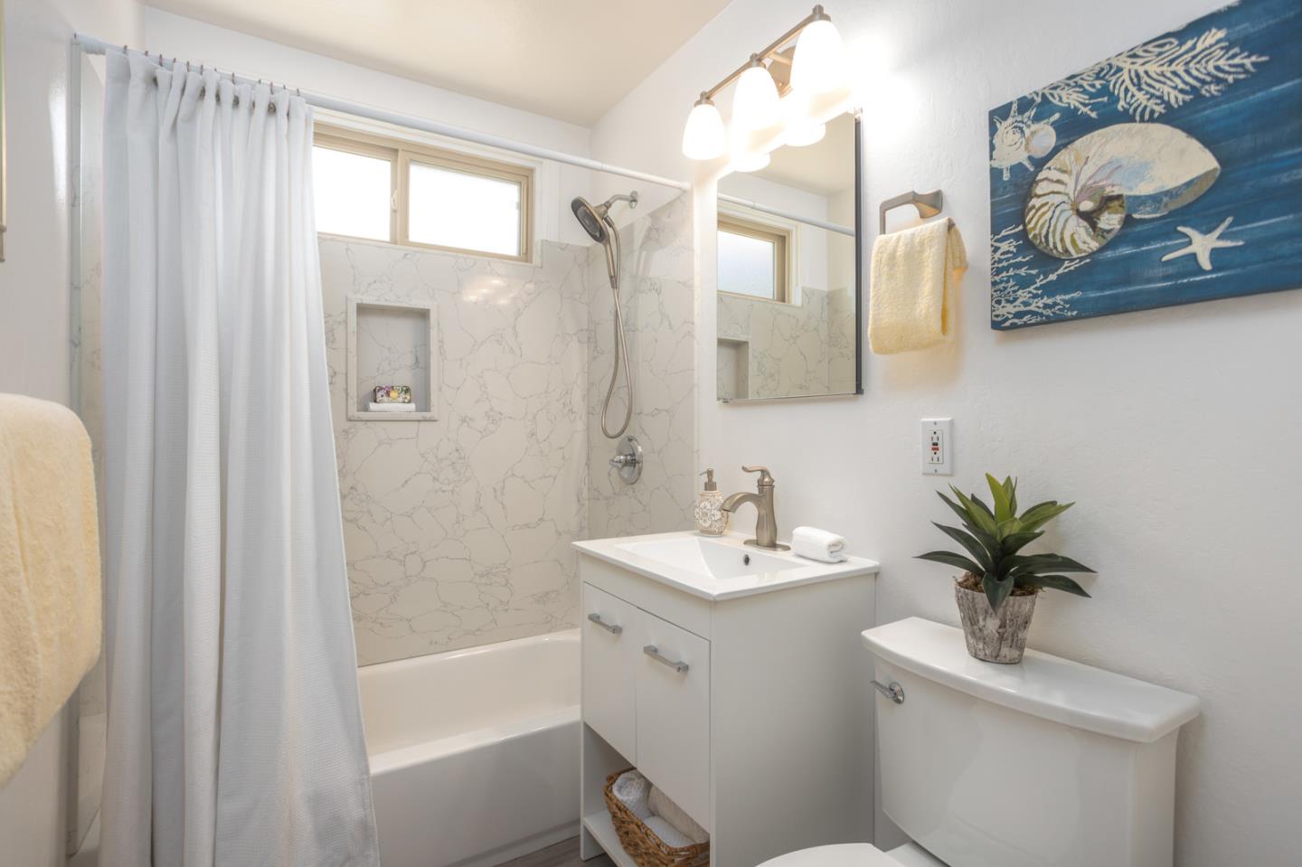 932 Crespi Drive Pacifica, CA 94044 - Photo 14 of 26 a bathroom with a sink a mirror a toilet and a shower