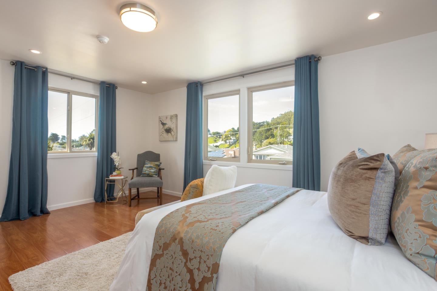 932 Crespi Drive Pacifica, CA 94044 - Photo 19 of 26 a bedroom with a large bed and wooden floor