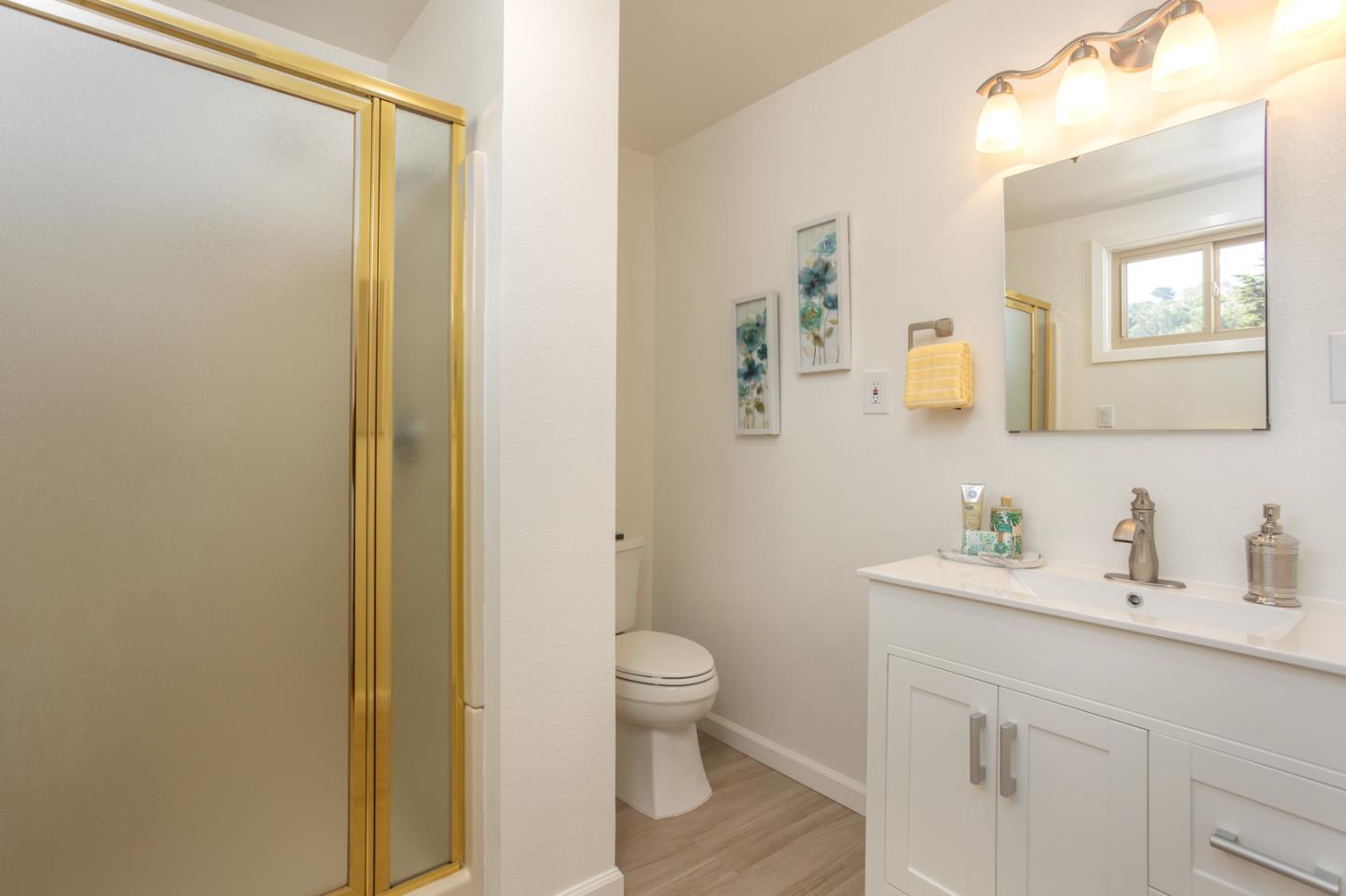 932 Crespi Drive Pacifica, CA 94044 - Photo 22 of 26 a bathroom with a toilet a sink a mirror and a shower