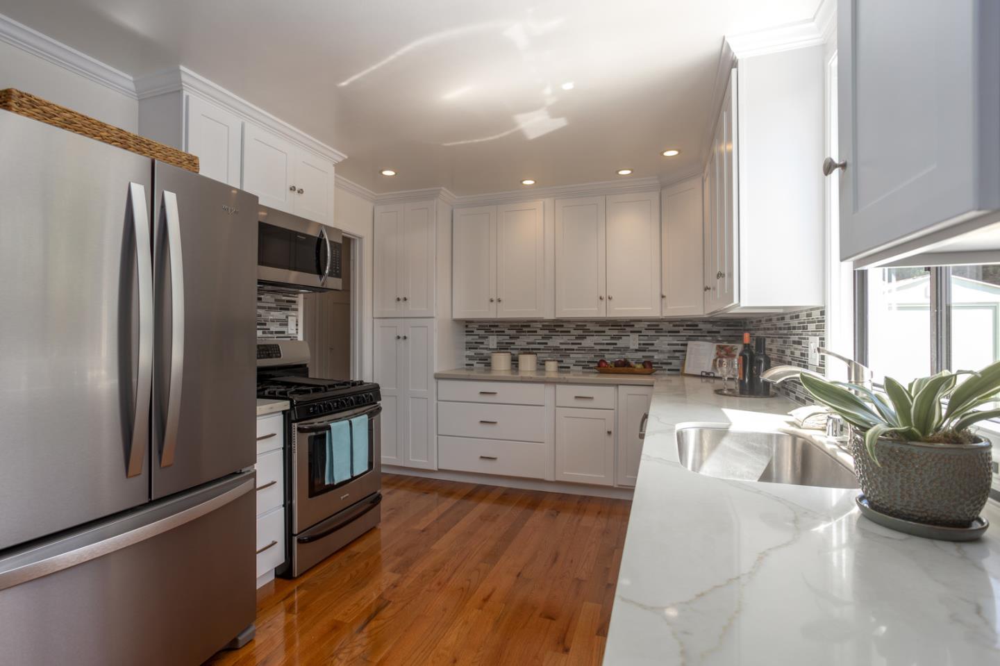932 Crespi Drive Pacifica, CA 94044 - Photo 7 of 26 a kitchen with granite countertop a refrigerator a sink a stove and cabinets