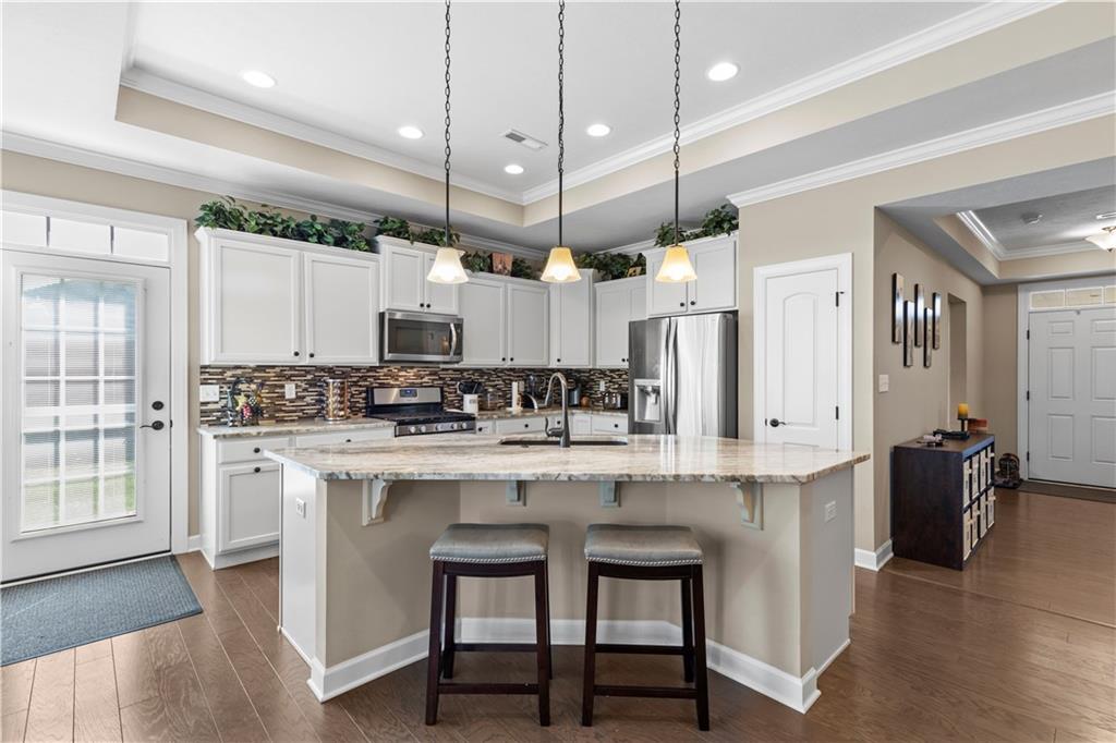 225 Brookside Drive Cranberry Township, PA 16066 - Photo 7 of 34 a kitchen with stainless steel appliances kitchen island a table chairs refrigerator and microwave