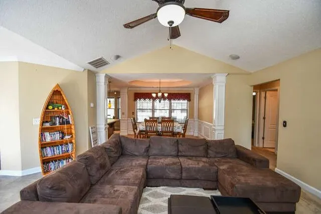 a view of a dining room and livingroom with furniture wooden floor a chandelier