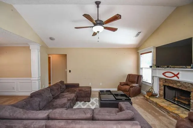 a view of a kitchen with kitchen island granite countertop a sink counter top space a stove and cabinets