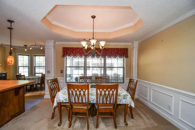 a kitchen with a stove a sink a chandelier and a refrigerator