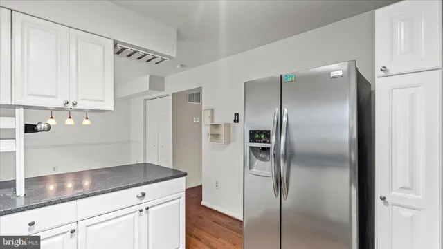 a modern kitchen with stainless steel appliances kitchen island a refrigerator sink and cabinets