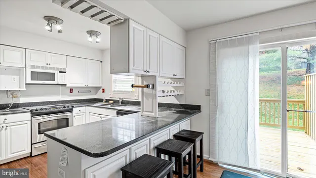 a kitchen with granite countertop white cabinets and white appliances