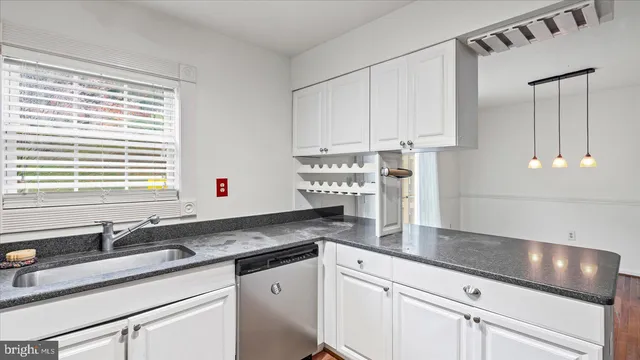 a kitchen with stainless steel appliances granite countertop a sink and a white cabinets