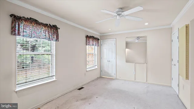a view of an empty room with a window and a kitchen