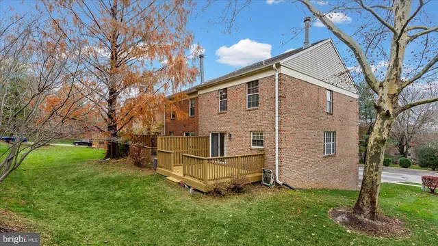 a view of a big house with a big yard and large trees