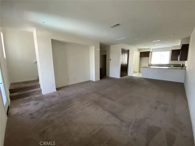 a view of a kitchen and an empty room