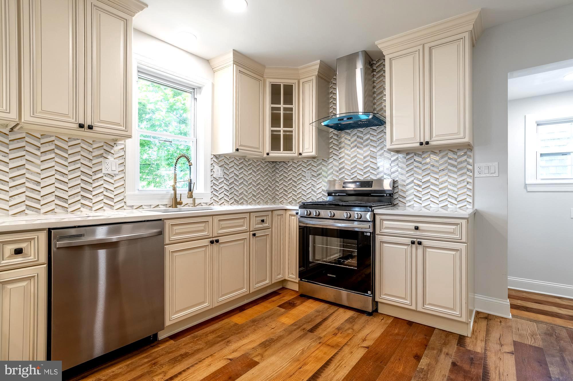 27 Cherry Avenue Maple Shade, NJ 08052 - Photo 11 of 50 a kitchen with stainless steel appliances granite countertop a stove a sink and white cabinets