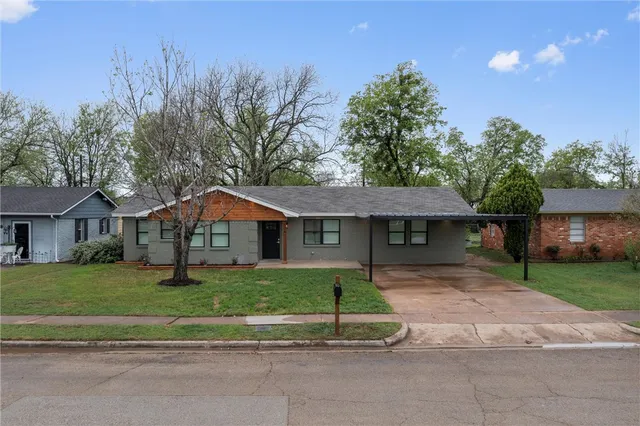 a front view of a house with a yard and trees