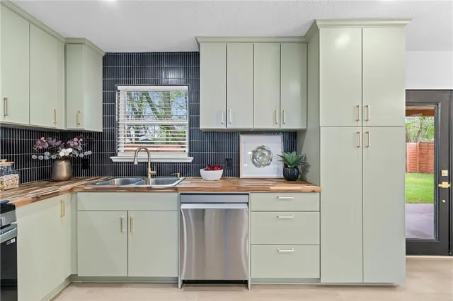 a kitchen with white cabinets sink and window
