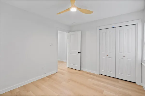 a view of an empty room with chandelier fan