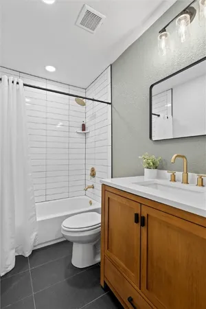 a bathroom with a granite countertop sink toilet and shower