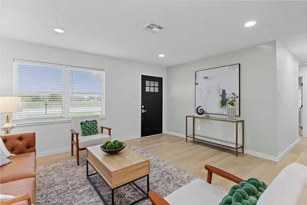 a living room with furniture and wooden floor
