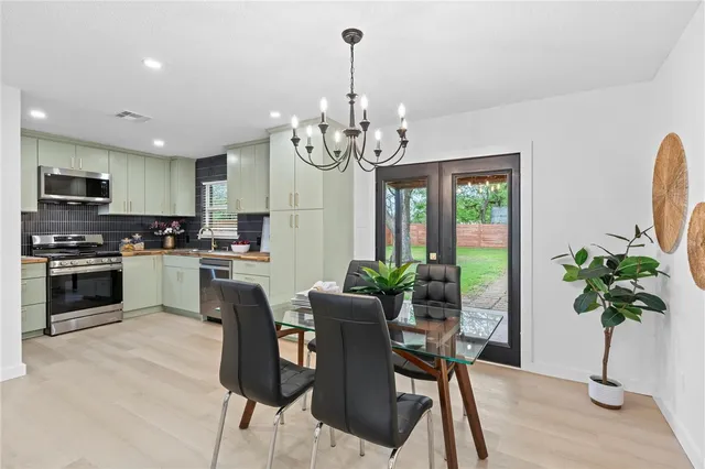 a kitchen with granite countertop stainless steel appliances dining table and a refrigerator