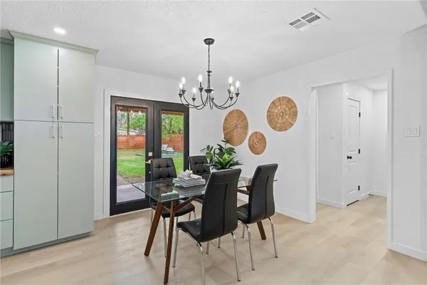 a view of a dining room and chandelier fan and wooden floor