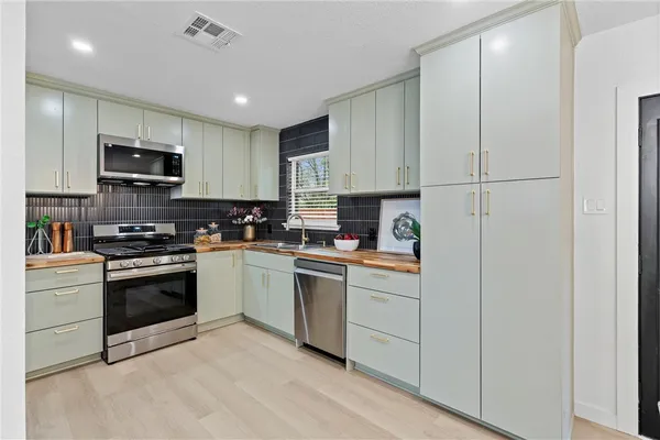 a kitchen with stainless steel appliances granite countertop a stove a sink and a refrigerator