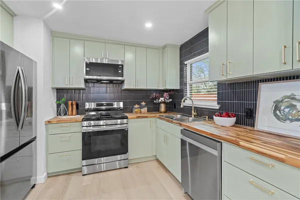 a kitchen with stainless steel appliances granite countertop a sink stove and refrigerator