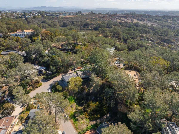 an aerial view of house with yard and mountain in back