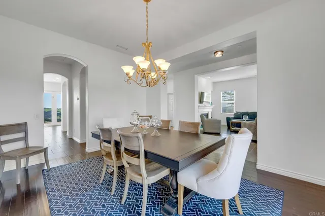 a dining room with furniture a rug and a chandelier